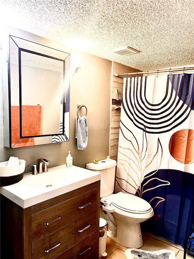 bathroom featuring vanity, toilet, tile patterned flooring, and a textured ceiling