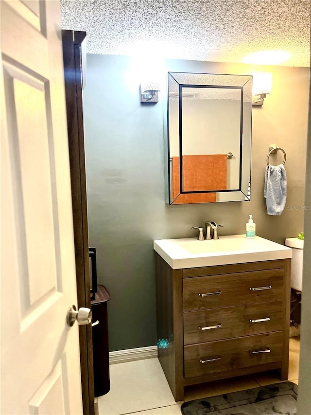 bathroom featuring vanity, tile patterned floors, and a textured ceiling