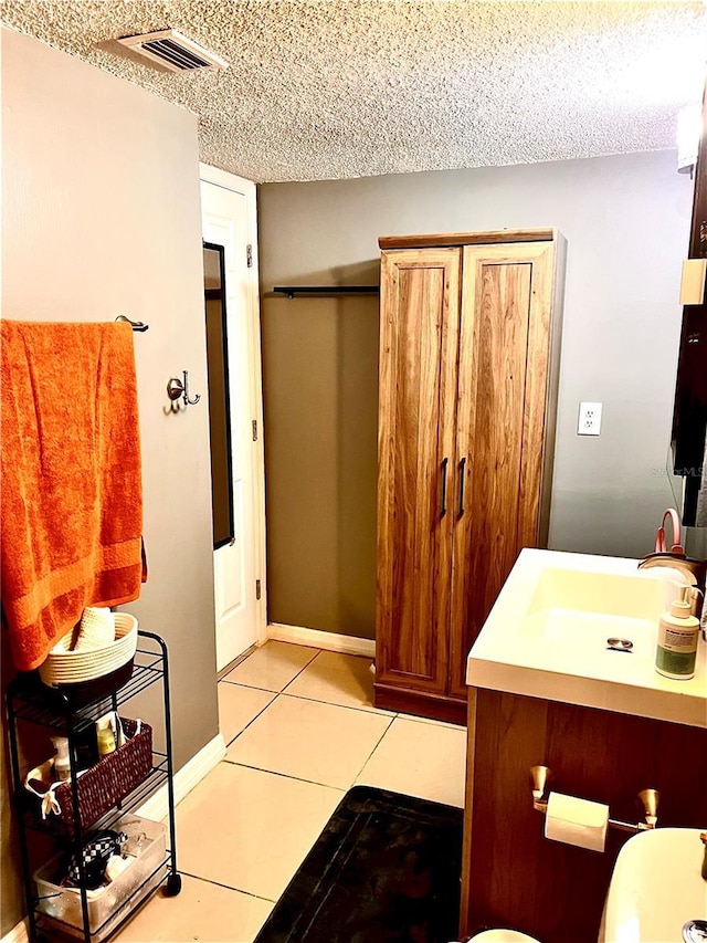 bathroom featuring tile patterned flooring, vanity, and a textured ceiling