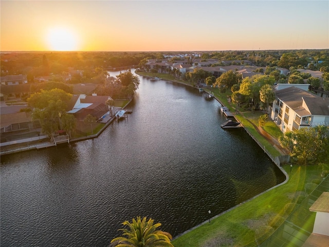 aerial view at dusk featuring a water view