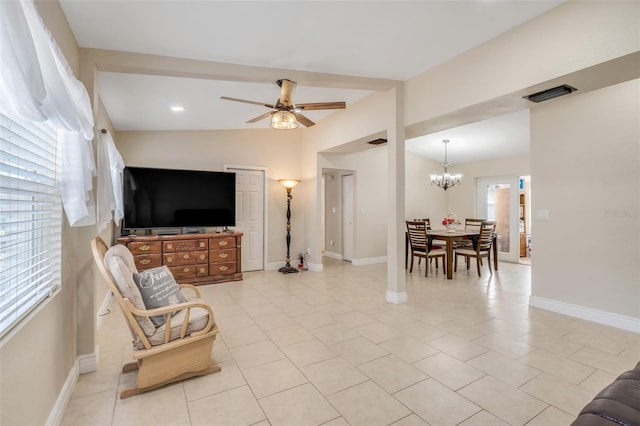 tiled living room with vaulted ceiling, plenty of natural light, and ceiling fan with notable chandelier