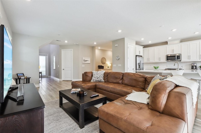 living room with sink and light hardwood / wood-style floors