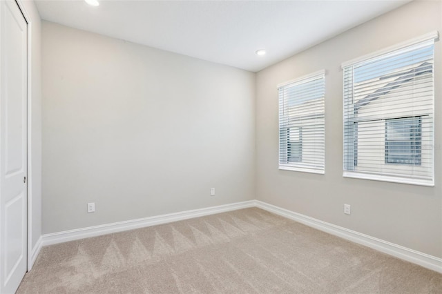 spare room featuring light colored carpet