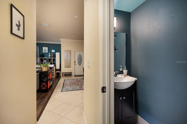 bathroom with tile patterned flooring, vanity, and ornamental molding