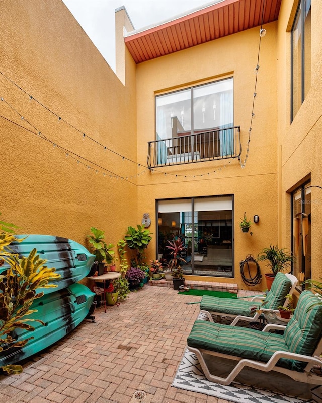 rear view of property with a balcony and a patio