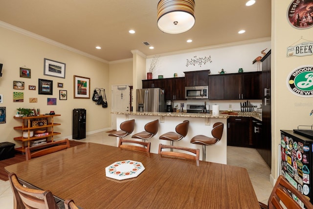 dining area featuring light tile patterned floors and crown molding