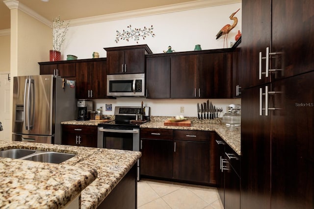 kitchen featuring ornamental molding, stainless steel appliances, light stone countertops, and dark brown cabinets