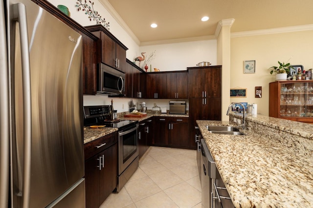 kitchen with sink, crown molding, dark brown cabinets, appliances with stainless steel finishes, and light stone countertops