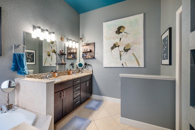 bathroom featuring tile patterned flooring, vanity, and a tub to relax in