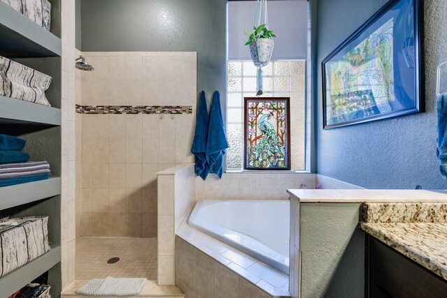 bathroom featuring vanity, plus walk in shower, and a wealth of natural light