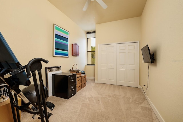 exercise area featuring light carpet and ceiling fan