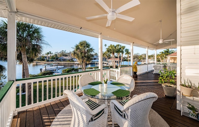 deck with ceiling fan and a water view