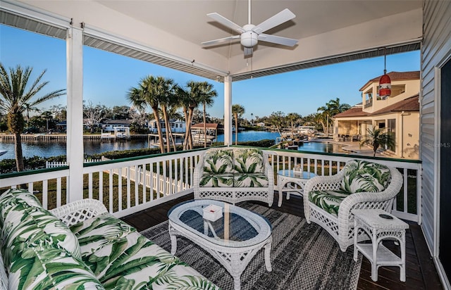 balcony featuring a deck with water view, ceiling fan, and outdoor lounge area