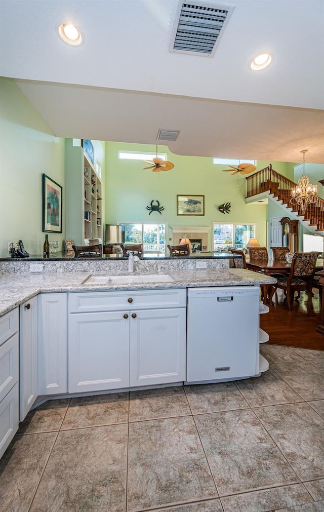 kitchen with white cabinetry, sink, ceiling fan with notable chandelier, and white dishwasher