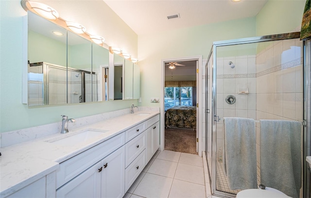 bathroom featuring a shower with door, vanity, and tile patterned floors