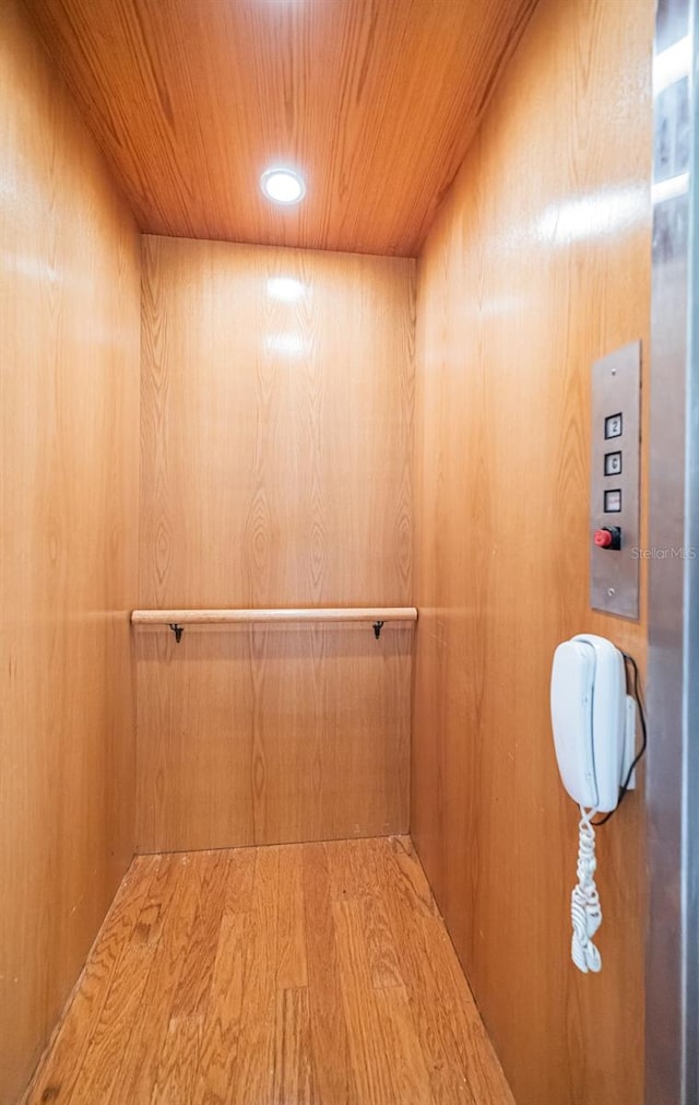 room details with hardwood / wood-style flooring, elevator, and wood ceiling