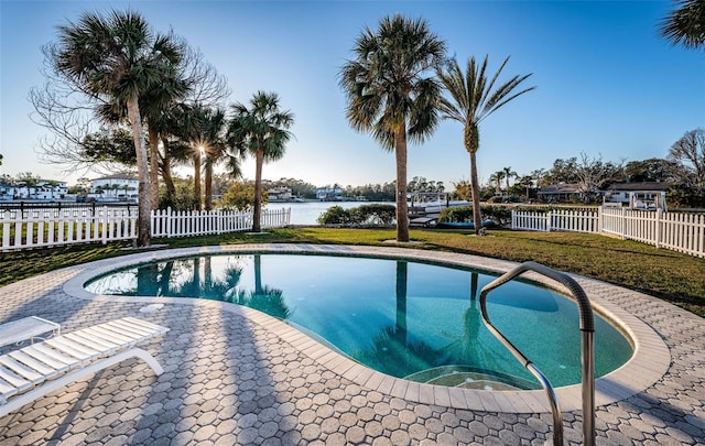 view of pool with a yard, a patio, and a water view