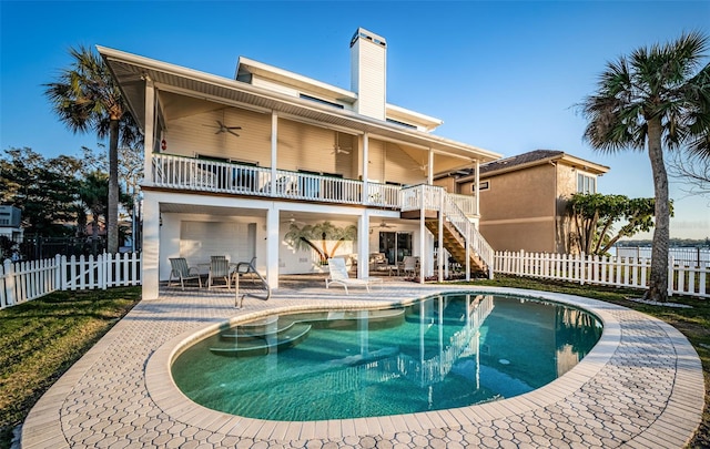 back of property featuring a fenced in pool, a balcony, ceiling fan, and a patio area