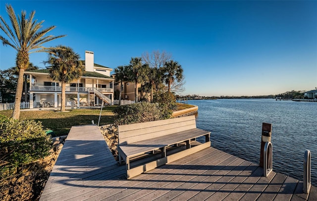 dock area with a balcony and a water view