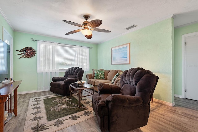 living room with ornamental molding, ceiling fan, and light hardwood / wood-style floors