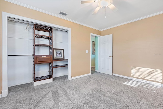 unfurnished bedroom with crown molding, a closet, ceiling fan, and carpet