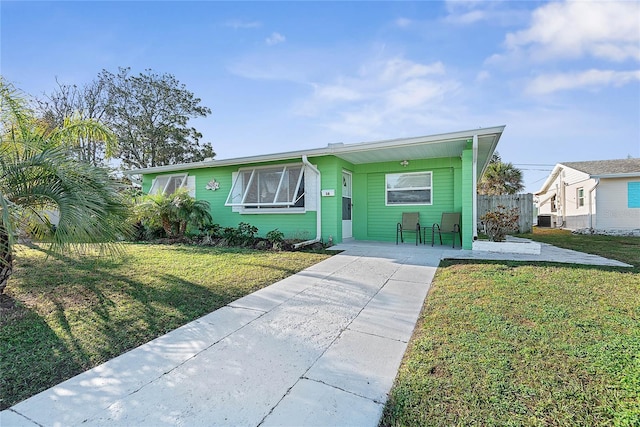 view of front of house featuring a carport, central AC unit, and a front yard