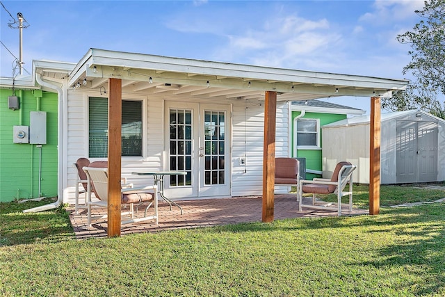 back of house with french doors, a yard, a patio area, and a storage shed