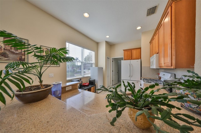 kitchen featuring backsplash, white appliances, and kitchen peninsula