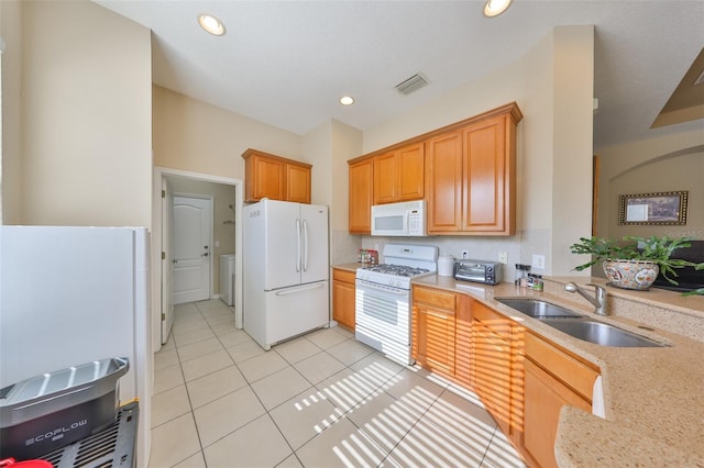 kitchen featuring light tile patterned flooring, white appliances, and sink