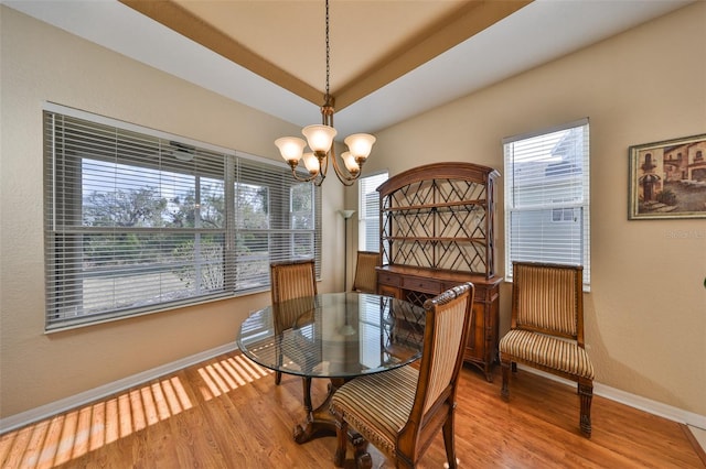 dining area featuring wood-type flooring and an inviting chandelier