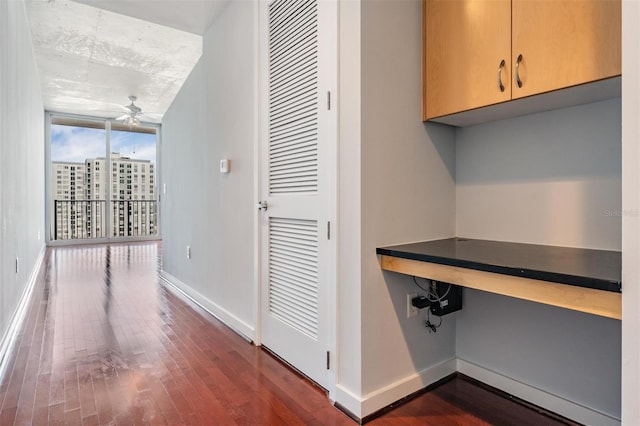 corridor featuring dark wood-type flooring and expansive windows