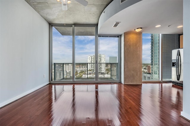 spare room featuring hardwood / wood-style flooring, floor to ceiling windows, and ceiling fan