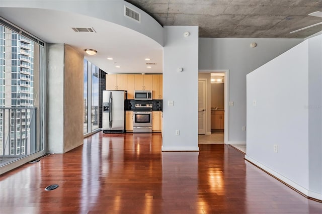 unfurnished living room featuring dark hardwood / wood-style flooring and expansive windows