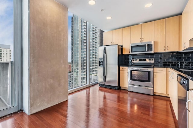 kitchen featuring dark hardwood / wood-style flooring, appliances with stainless steel finishes, backsplash, floor to ceiling windows, and light brown cabinetry