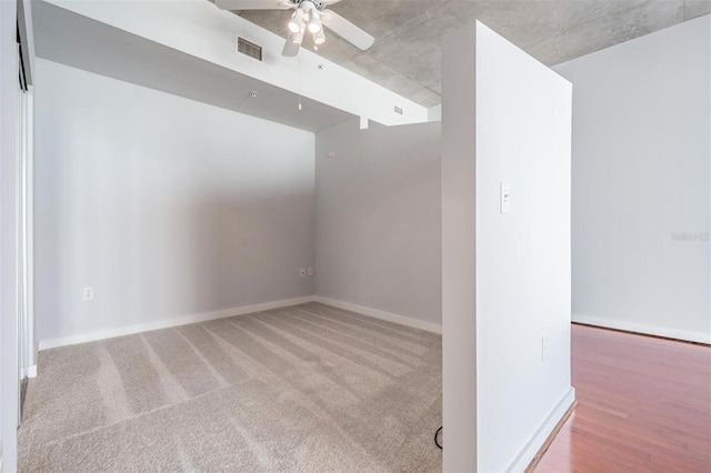 carpeted spare room featuring ceiling fan