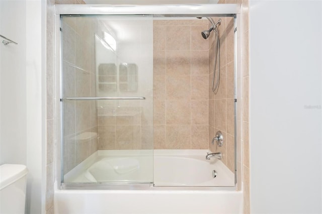 bathroom with bath / shower combo with glass door and toilet