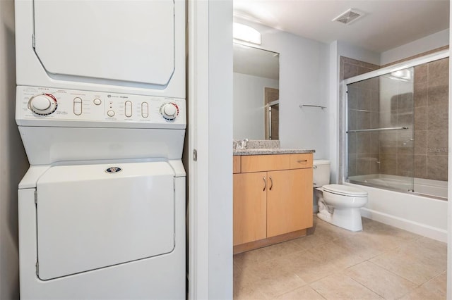 washroom with stacked washer and dryer and light tile patterned flooring