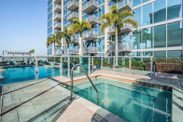 view of swimming pool featuring a community hot tub and a patio area