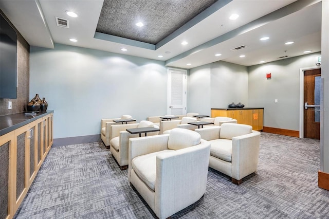 carpeted cinema with a tray ceiling