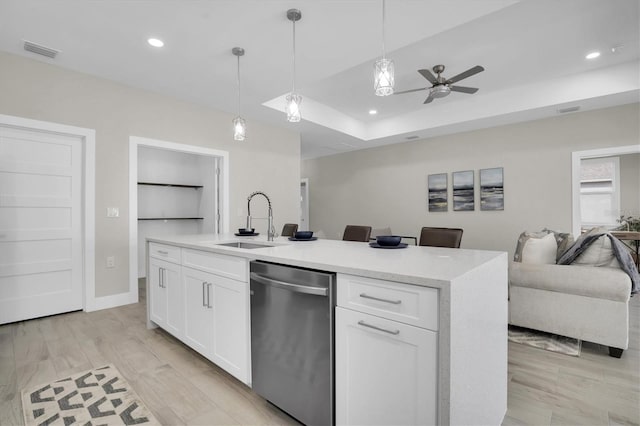 kitchen featuring sink, white cabinets, hanging light fixtures, stainless steel dishwasher, and a center island with sink