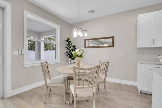 dining space with a notable chandelier and light hardwood / wood-style flooring