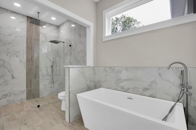 bathroom with tile walls, shower with separate bathtub, and toilet