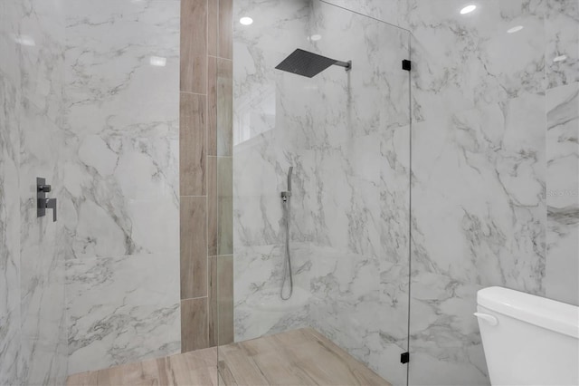 bathroom with tiled shower and toilet