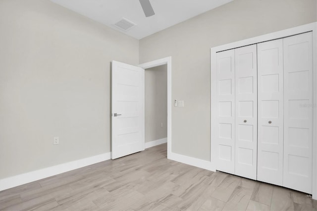 unfurnished bedroom with ceiling fan, a closet, and light wood-type flooring