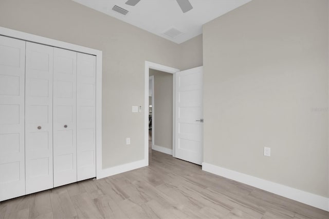 unfurnished bedroom featuring light hardwood / wood-style flooring, ceiling fan, and a closet