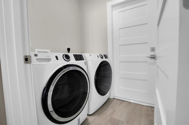 laundry room featuring washer and dryer and light wood-type flooring