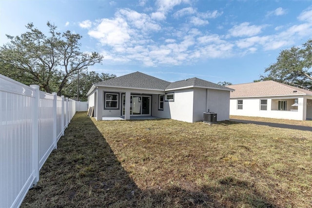 back of property with cooling unit, a yard, and a patio area