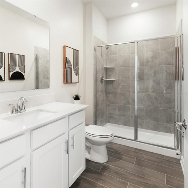 bathroom with vanity, toilet, and a shower with shower door