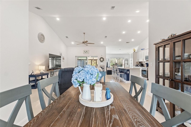 dining space featuring sink, high vaulted ceiling, and ceiling fan