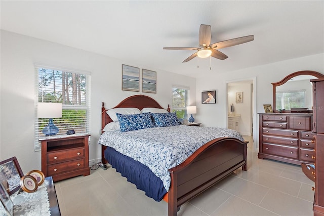 bedroom with multiple windows, light tile patterned flooring, ensuite bathroom, and ceiling fan